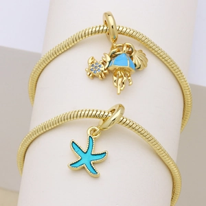 Détails des breloques marines dorées avec émail bleu sur le bracelet à maille serpent