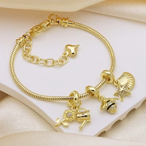 Golden snake chain bracelet with sunflower, bee, and starfish charms on silk