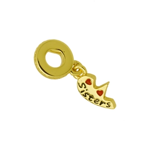 Détail d'un pendentif cœur doré avec gravure Sisters et motifs de cœurs rouges