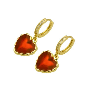 Macro shot of gold heart dangle earrings with red gems and cubic zirconia inlay