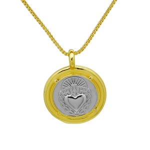 Macro detail of a two-tone 18k gold plated round pendant with embossed heart and sunburst