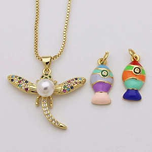 Collier doré tendance avec pendentif libellule en perle et breloques de poissons émaillés