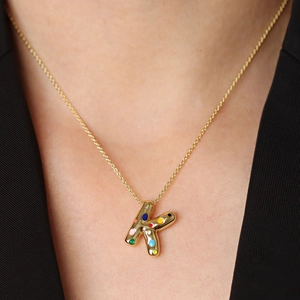 Golden 3D balloon letter K necklace with colorful enamel dots on a delicate chain