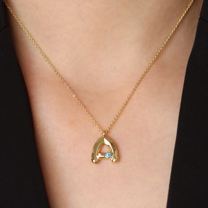 Gold Evil Eye Letter A pendant necklace on minimalist chain worn by model close-up view