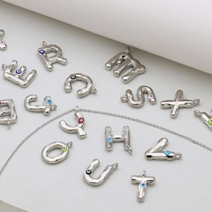 Zilveren letterhangers met kleurrijke Evil Eye emaille details aan een mooie ketting