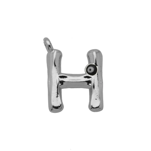 Detail van zilveren letter H hanger met onregelmatige textuur en boze oog accent