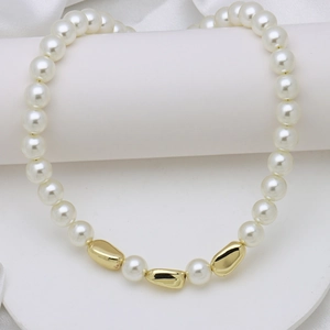 Detail of white pearls and gold metal beads on a luxurious silk background