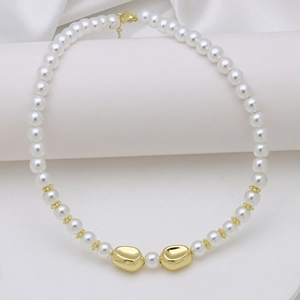 Detail of elegant pearl necklace featuring golden irregular beads on white silk background