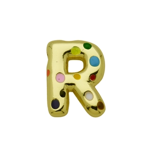 Macro shot of 3D golden bubble letter R pendant with colorful enamel polka dots detail