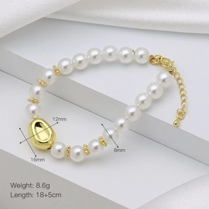 Detailed view of pearl bracelet featuring a gold bean pendant and adjustable lobster clasp