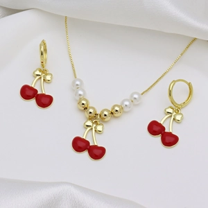 Dettaglio della collana con ciliegie dorate, pendenti in smalto rosso e perle su seta bianca