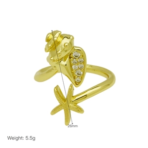 Détail d'une bague marine dorée avec coquillage et étoile de mer en pavé de zircons
