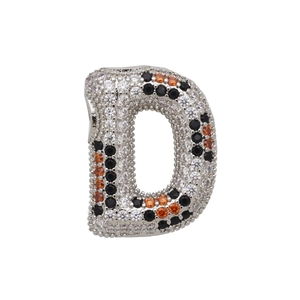 Detailed macro of the letter D pendant with white black and orange cubic zirconia stones