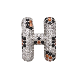 Macro view of crystal encrusted silver letter H pendant with orange and black zircon stones