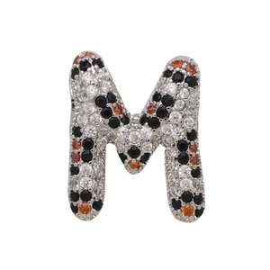 Macro detail of alphabet M pendant with micro-paved white, black and orange zircons