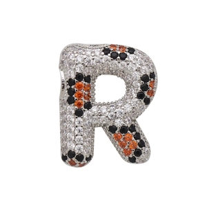 Macro detail of alphabet R pendant featuring vibrant silver, black and orange zircon stones