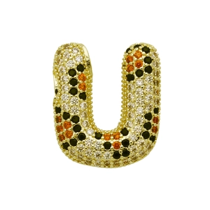 Makro-Detail des goldenen U-Buchstabenanhängers mit weißen, schwarzen und orangefarbenen Zirkonen