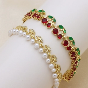 Elegant gold fruit bracelets with pearls, red cherry gems, and green leaf crystals