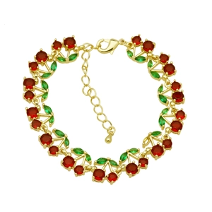Macro detail of cherry charm bracelet with red and green gemstones on gold link chain