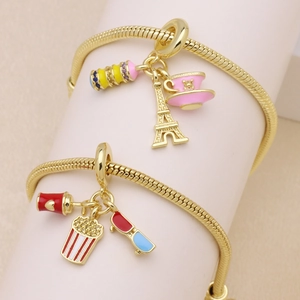 Golden snake chain charm bracelet with Eiffel Tower, popcorn and enamel pendants