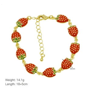 Detailed macro view of gold-plated bracelet with 9 red enamel strawberry charms and lobster clasp