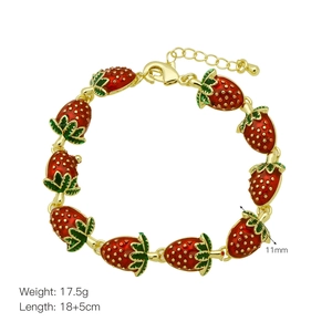 Detailed view of adjustable strawberry charm bracelet with red enamel and golden leaf