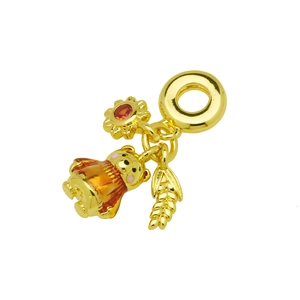 Detail of gold pendant charm featuring a translucent bear, sunflower, and leaf textures