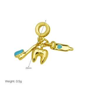 Detailed close-up of gold dental charms featuring a toothbrush, tooth and blue heart toothpaste
