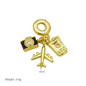 Travel charms detail featuring a gold airplane, camera with zircon, and passport pendant