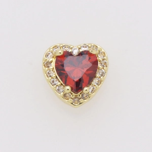 Macro di un ciondolo a cuore in oro 18k con una grande pietra rossa e un alone di zirconi