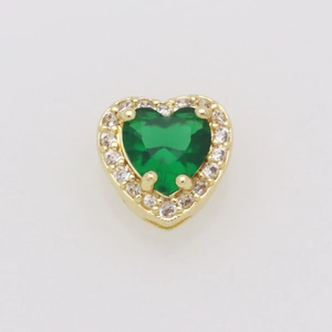 Dettaglio macro del ciondolo a cuore con zircone smeraldo e placcatura in oro
