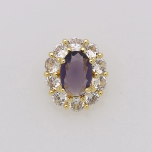Dettaglio macro del ciondolo floreale vintage con gemma viola ovale e placcatura 18k
