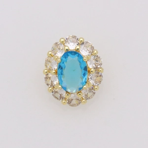Dettaglio del ciondolo in oro 18k con pietra blu ovale e contorno di cristalli bianchi