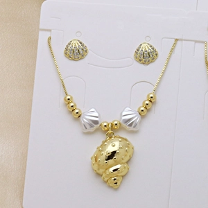 Set collana con conchiglia e orecchini a ventaglio dorati con perle bianche su carta