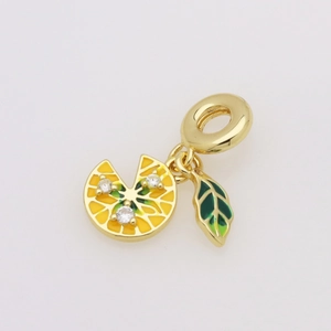 Macro shot of lemon slice pendant with yellow enamel, green leaf, and zircon stones