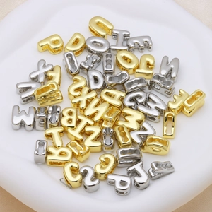 Macro shot of 3D puffy bubble alphabet beads in gold and silver finish for DIY jewelry
