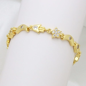 Primer plano detallado de la pulsera bañada en oro de 18K con estrellas de circonita y hamsa