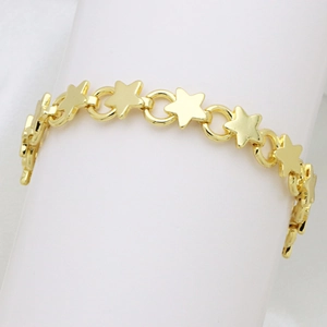 Primer plano de pulsera dorada con eslabones de estrellas y circonitas brillantes