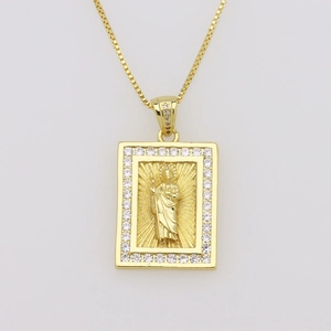 Close-up of gold cross pendant with St. Jude relief and sparkling zircon inlay