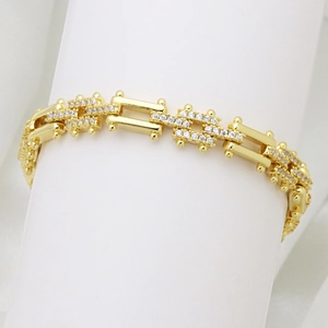 Vista macro dell'bracciale placcato oro 18K con zirconi e maglie quadrate di lusso