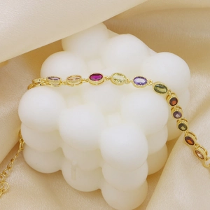 Elegant gold bracelet featuring oval-cut colorful gemstones and adjustable chain link