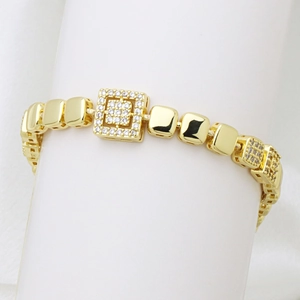 Dettaglio del bracciale a catena quadrata dorata con micro-pavé di zirconi