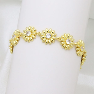Macro detail of gold daisy bracelet links with sparkling clear crystals and metallic finish