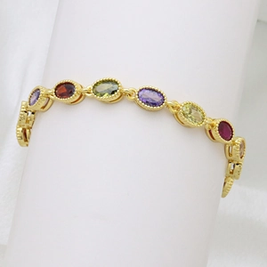Detail view of multi-color oval gemstones on a gold-plated bracelet with beaded edges