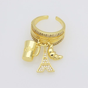Detail van gouden ring met bedeltjes van de Eiffeltoren, croissant en koffiekop