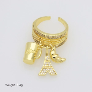 Detail van verstelbare gouden ring met bedeltjes van koffie, Eiffeltoren en croissant
