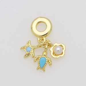 Macro shot of gold sea turtle starfish and seashell charms with blue enamel