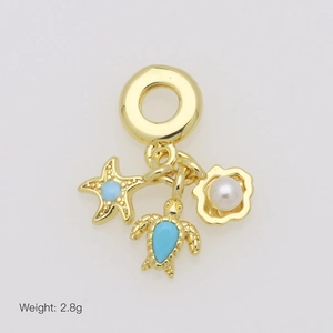 Macro detail of ocean charms featuring sea turtle, starfish, and pearl shell in gold