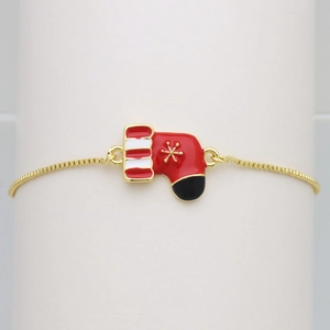 Detailed close-up of a red enamel Christmas stocking charm on a golden box chain bracelet