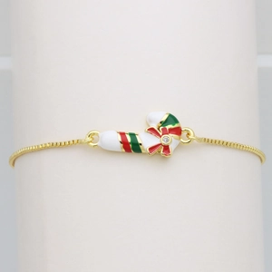 Detail of Christmas candy cane charm on gold chain with red bow and crystal inlay